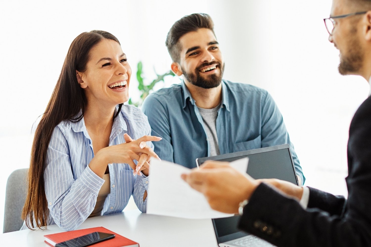 Pareja sonriente recibiendo asesoría jurídica inmobiliaria de Domus Consulting